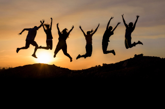 Silhouettes of people jumping